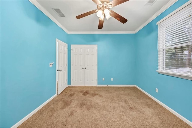 empty room with crown molding, light colored carpet, and ceiling fan