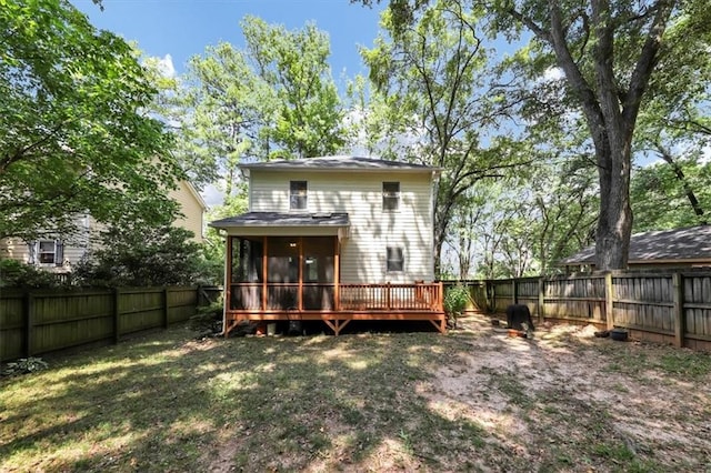 back of property featuring a yard, a deck, and a sunroom