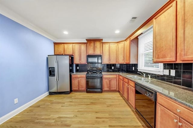 kitchen featuring light hardwood / wood-style flooring, tasteful backsplash, black appliances, and sink