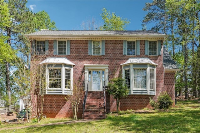 view of front facade featuring brick siding and a front yard