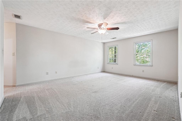 empty room featuring visible vents, carpet, ceiling fan, and baseboards