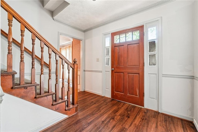entryway featuring crown molding, a textured ceiling, baseboards, wood finished floors, and stairway