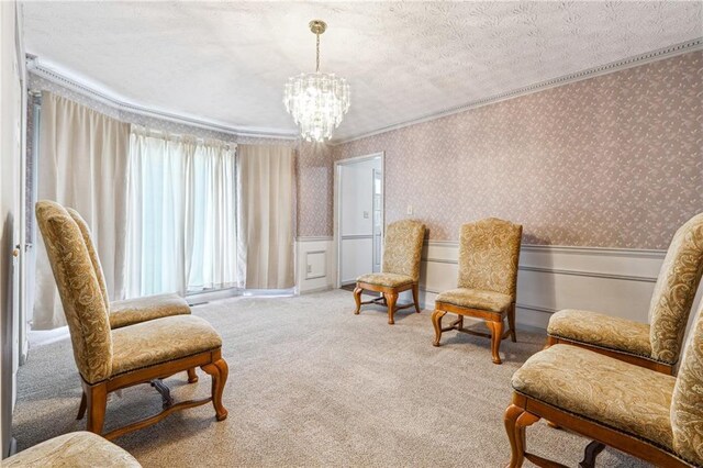 living area featuring ornamental molding, wainscoting, wallpapered walls, carpet, and a notable chandelier