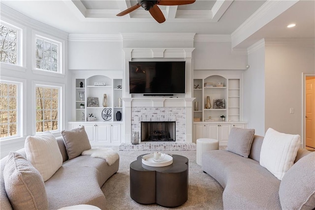 living area featuring ornamental molding, ceiling fan, a brick fireplace, and plenty of natural light