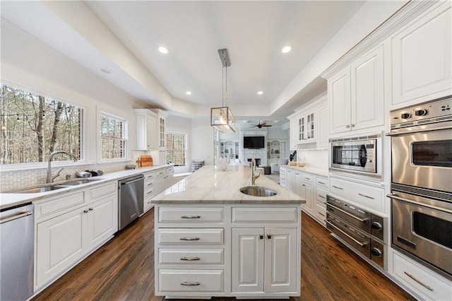 kitchen featuring ceiling fan, open floor plan, stainless steel appliances, and a sink