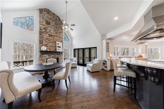 dining area featuring dark wood finished floors, high vaulted ceiling, a ceiling fan, and a healthy amount of sunlight
