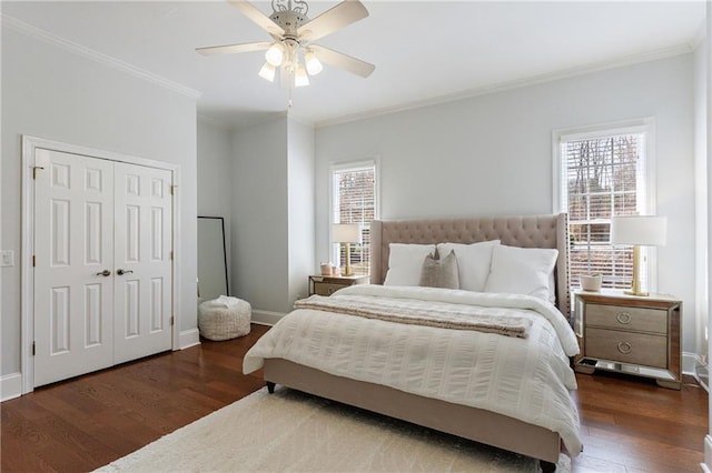bedroom featuring a closet, a ceiling fan, baseboards, ornamental molding, and wood finished floors