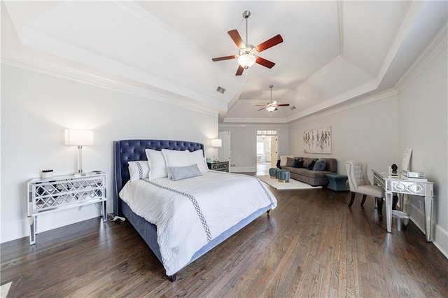 bedroom featuring wood finished floors, a tray ceiling, and visible vents