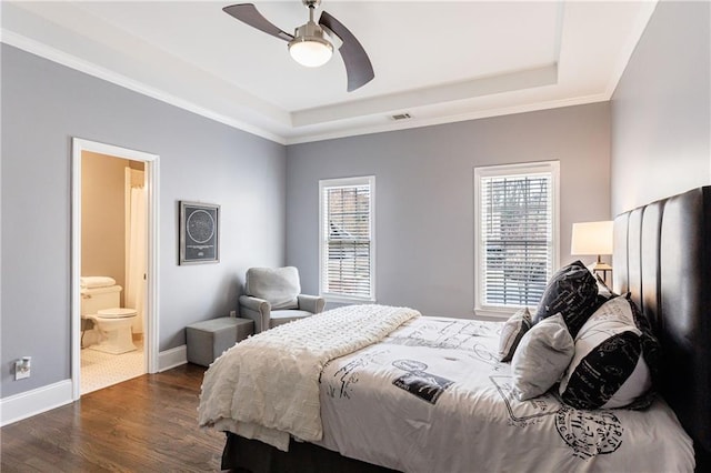 bedroom featuring crown molding, visible vents, dark wood-style floors, and a tray ceiling