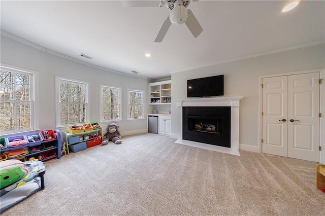 rec room with carpet, ceiling fan, and crown molding