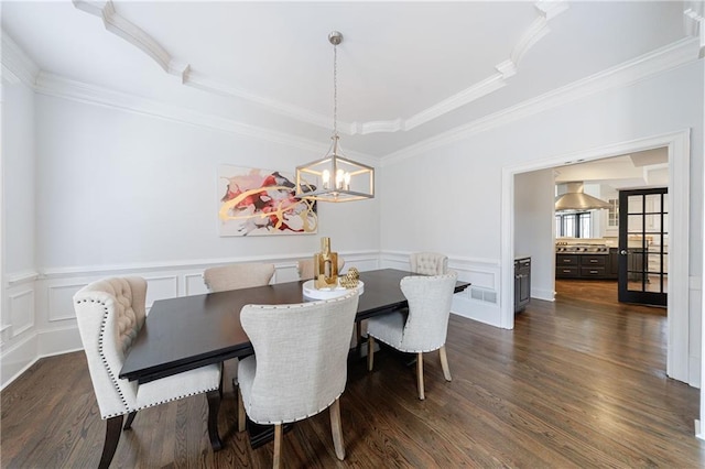 dining room featuring wainscoting, dark wood finished floors, and crown molding