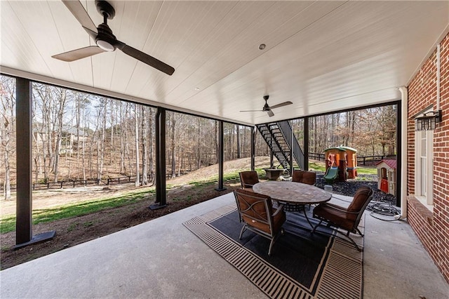 view of patio with a ceiling fan, outdoor dining area, and stairs