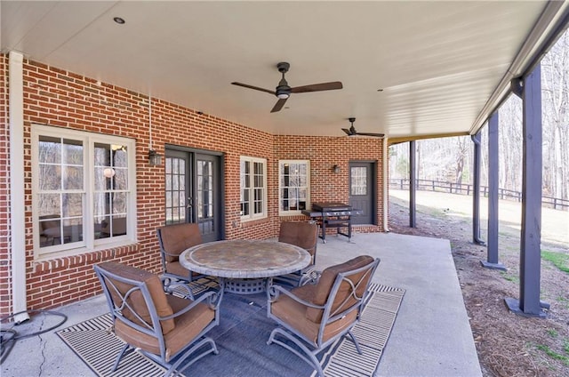 view of patio / terrace featuring fence, outdoor dining space, a ceiling fan, and french doors