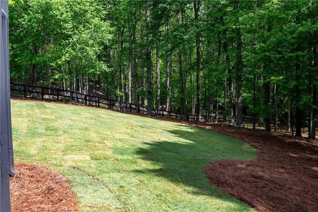 view of yard with a forest view and a fenced backyard