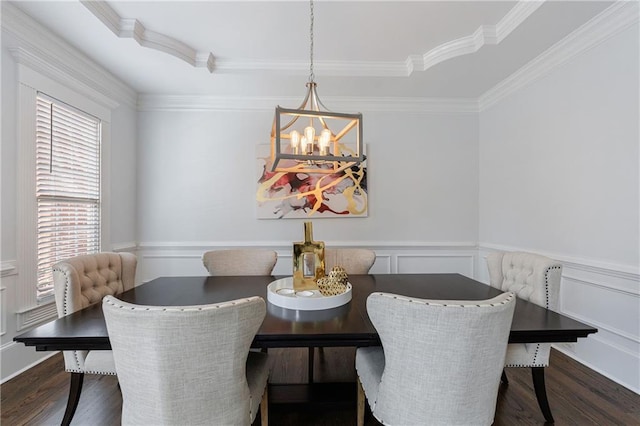 dining room featuring dark wood-style flooring, ornamental molding, a wainscoted wall, and a notable chandelier