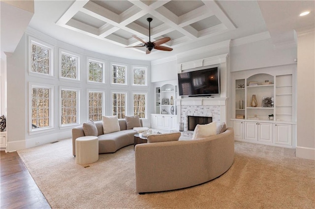 living room with a brick fireplace, a towering ceiling, a ceiling fan, and plenty of natural light