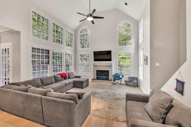 1253 Rivermark Ct, Lawrenceville, GA 30043 - living area featuring high vaulted ceiling, wood finished floors, a ceiling fan, and a fireplace with raised hearth
