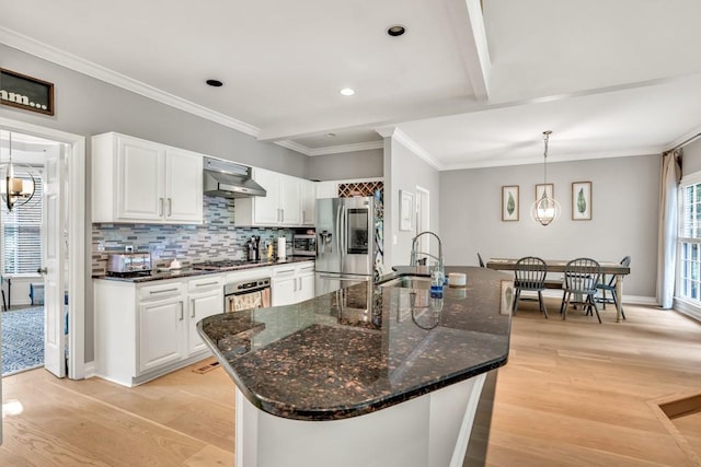 1253 Rivermark Ct, Lawrenceville, GA 30043 - kitchen with appliances with stainless steel finishes, a sink, under cabinet range hood, light wood finished floors, and white cabinetry