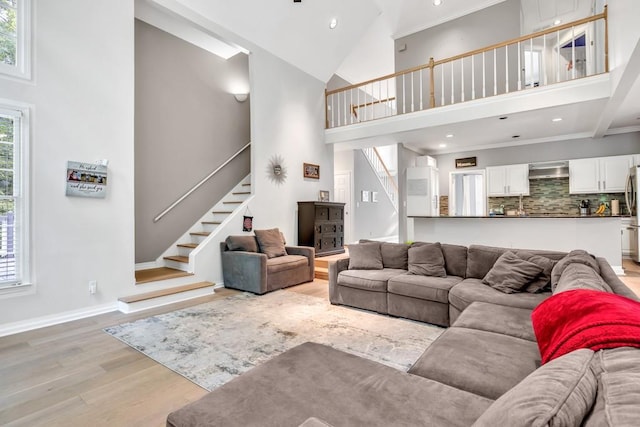 1253 Rivermark Ct, Lawrenceville, GA 30043 - living room with high vaulted ceiling, stairway, light wood-style flooring, plenty of natural light, and recessed lighting