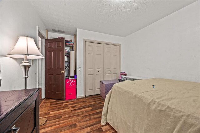 1230 Brook Meadow Ct, Lawrenceville, GA 30045 - bedroom featuring dark wood finished floors, a closet, and a textured ceiling