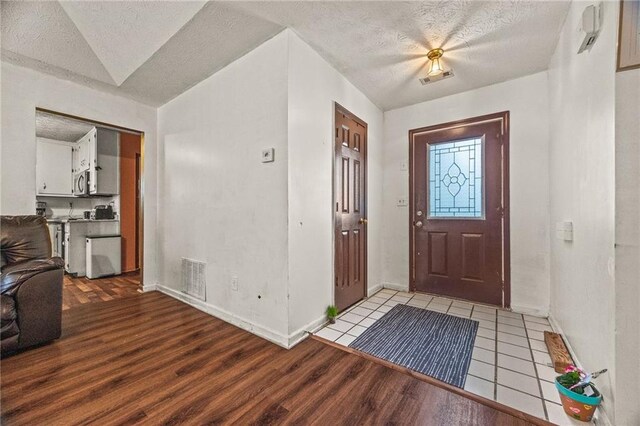 1230 Brook Meadow Ct, Lawrenceville, GA 30045 - entrance foyer with light wood-style flooring, a textured ceiling, and baseboards