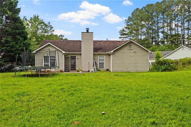 1230 Brook Meadow Ct, Lawrenceville, GA 30045 - back of property featuring a trampoline, a lawn, and a chimney