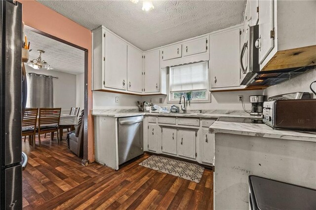 1230 Brook Meadow Ct, Lawrenceville, GA 30045 - kitchen with appliances with stainless steel finishes, dark wood finished floors, a sink, a textured ceiling, and white cabinets
