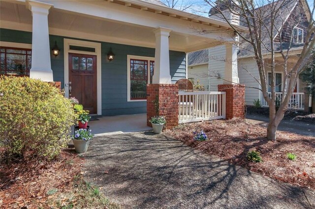 property entrance featuring brick siding and covered porch