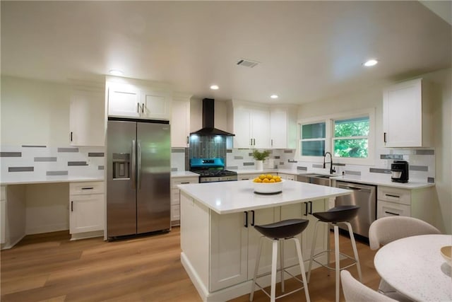 1342 Carter Rd, Decatur, GA 30030 - kitchen featuring appliances with stainless steel finishes, wall chimney range hood, a sink, white cabinets, and recessed lighting