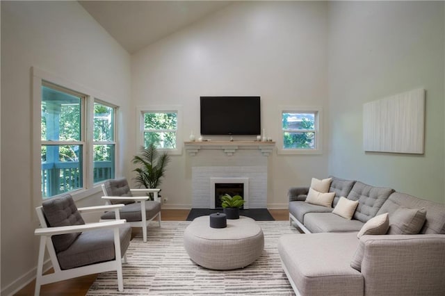 1342 Carter Rd, Decatur, GA 30030 - living room featuring high vaulted ceiling, wood finished floors, baseboards, and a brick fireplace