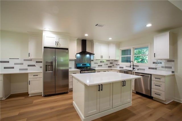 1342 Carter Rd, Decatur, GA 30030 - kitchen with stainless steel appliances, wall chimney range hood, a sink, white cabinetry, and backsplash
