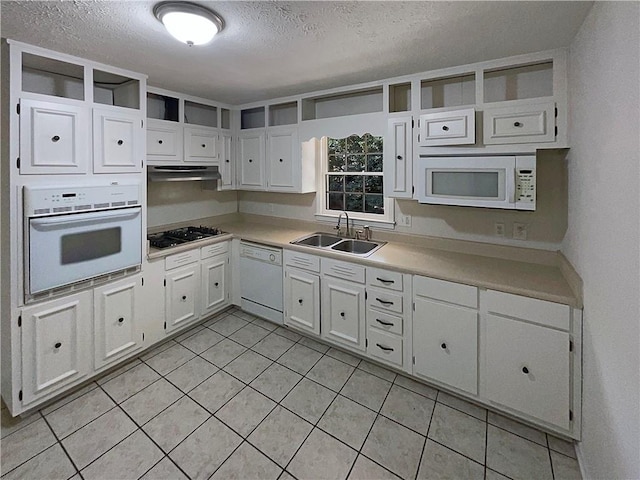 kitchen featuring a textured ceiling, white appliances, white cabinetry, and sink