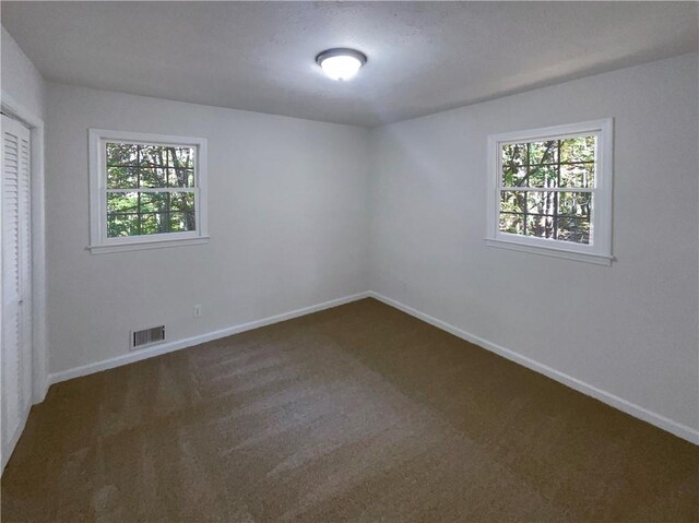 empty room featuring dark carpet