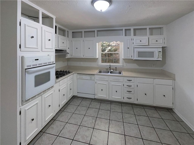 kitchen with a textured ceiling, white cabinetry, white appliances, and sink