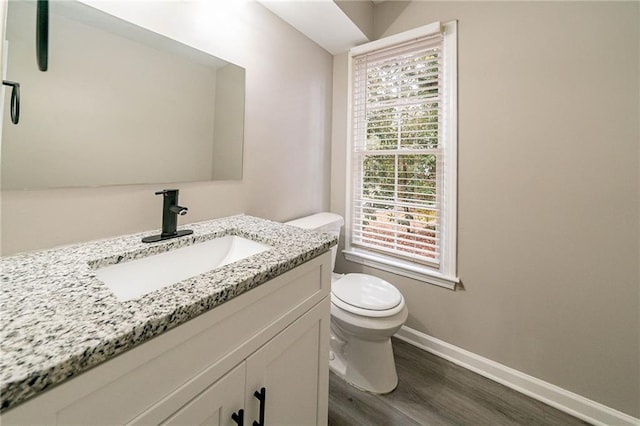 bathroom with wood-type flooring, vanity, and toilet