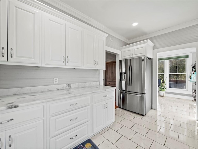 kitchen with white cabinets, light stone counters, stainless steel fridge with ice dispenser, and ornamental molding