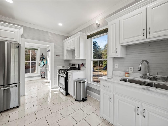 kitchen featuring white cabinets, stainless steel appliances, plenty of natural light, and sink