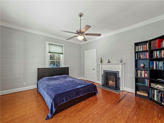 bedroom with hardwood / wood-style flooring, ceiling fan, and crown molding