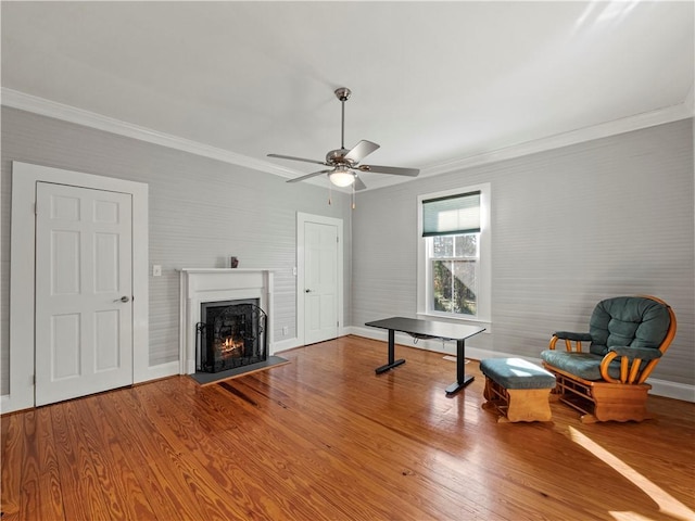 sitting room with hardwood / wood-style flooring, ceiling fan, and ornamental molding