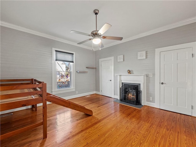 interior space with hardwood / wood-style floors, ceiling fan, and ornamental molding