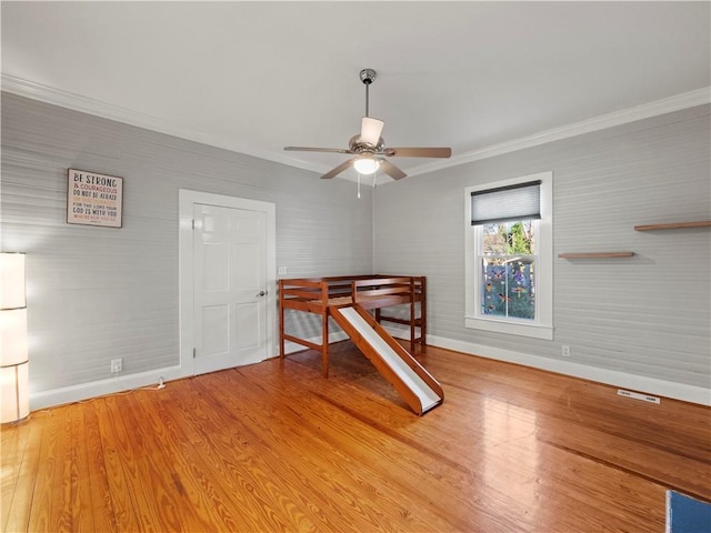 bedroom featuring ceiling fan, wood-type flooring, and ornamental molding