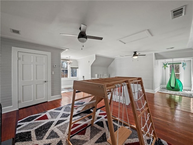 interior space with ceiling fan with notable chandelier, lofted ceiling, and dark wood-type flooring