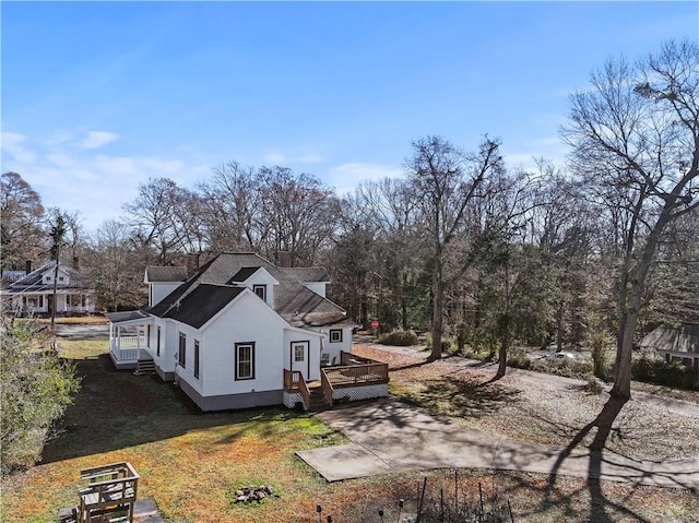 view of side of home with a wooden deck and a yard