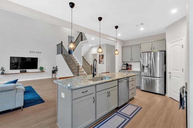 kitchen featuring a sink, stainless steel appliances, light wood-type flooring, and gray cabinets