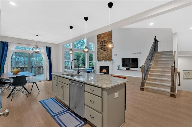 kitchen with dishwasher, plenty of natural light, light wood-type flooring, and a sink