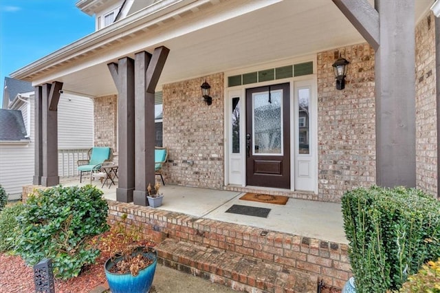 property entrance featuring brick siding and covered porch