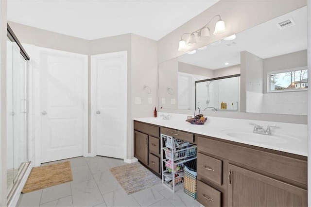 bathroom featuring visible vents, marble finish floor, a stall shower, and a sink