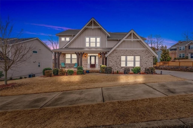 craftsman-style house featuring brick siding, covered porch, and central AC