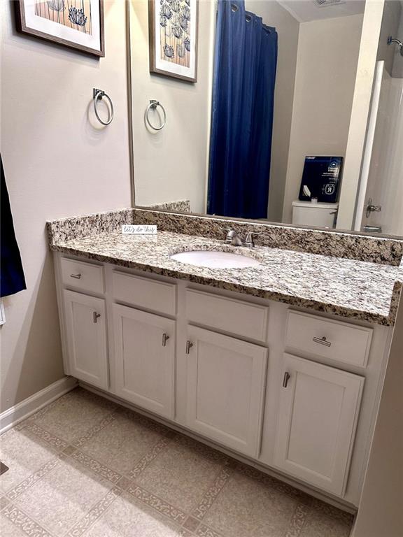 bathroom featuring a shower with curtain, vanity, and toilet