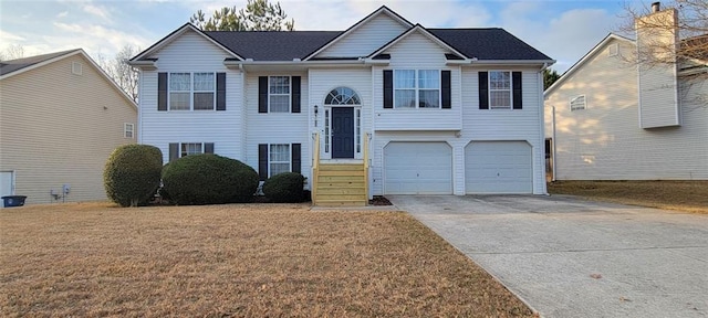 raised ranch featuring a garage and a front yard